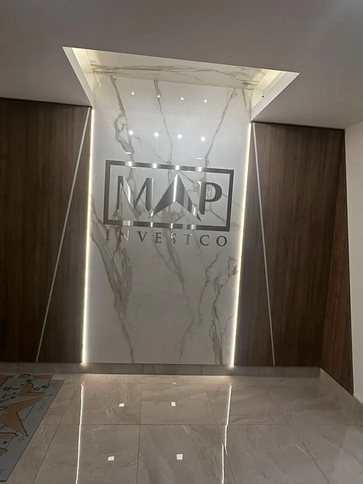 Backlit marble feature wall with MJP signage and wood slat returns