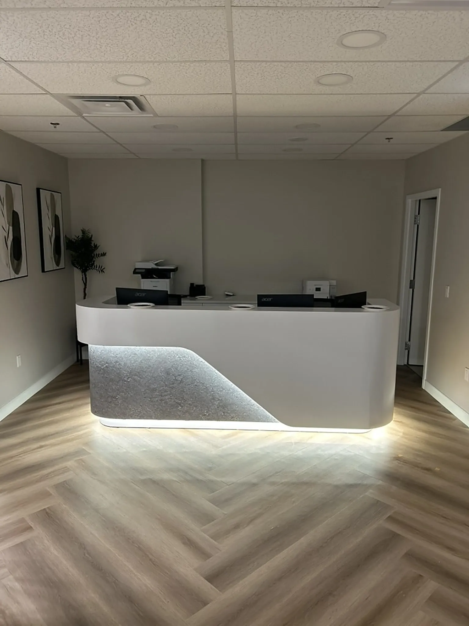 Reception area with a curved desk and herringbone floor