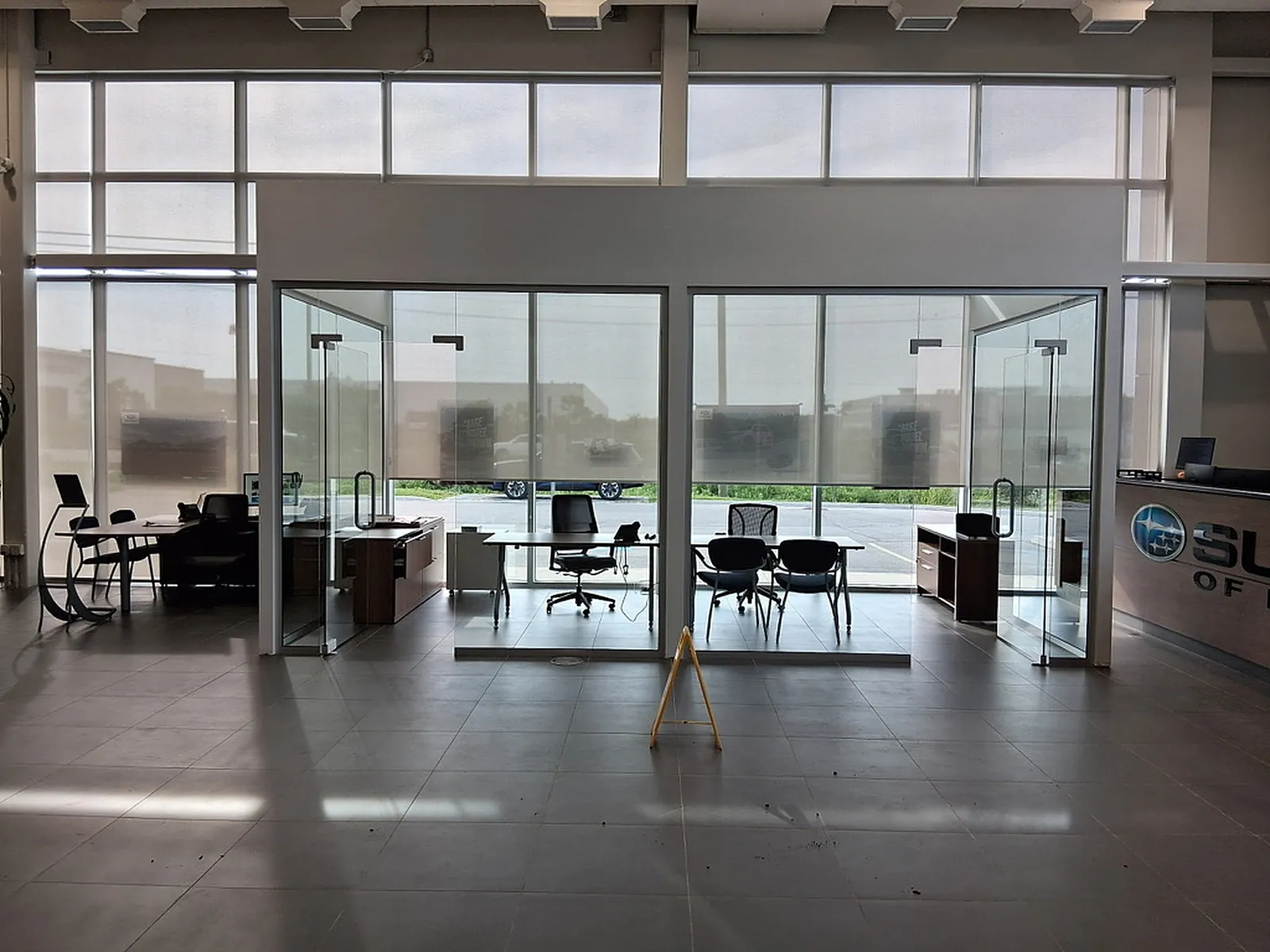 Row of glass-partition offices with a window wall behind